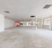 PREDAJ priestoru na frekventovanom mieste BRATISLAVA - Rozľahlé prázdne obchodné priestory s bielymi stenami a podhľadovým stropom.
