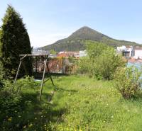 Rodinný dom v rekonštrukcii, Ružomberok - Na ulici Nám. A. Hlinku, zelený pozemok rodinného domu s hojdačkou, výhľad na kopce.