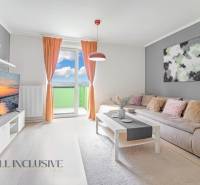 ALL INCLUSIVE REAL I KRÁSNY 2 IZBOVÝ BYT S BALKÓNOM GALANTA WEST - Obývačka 2-izbového bytu so sedačkou, televízorom a balkónom, svetlé závesy a doplnky.