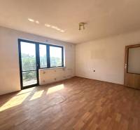Na predaj Rodinný dom Drietoma – pozemok 745 m2  - Svetlá izba v rodinnom dome s drevenou podlahou a veľkými oknami.