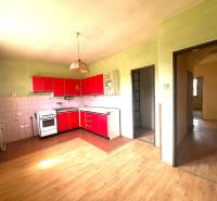 Na predaj Rodinný dom Drietoma – pozemok 745 m2  - Kuchyňa v rodinnom dome s červenými skrinkami a drevenou podlahou.