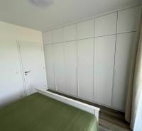 Prenájom 2-izb bytu Bory, NOVOSTAVBA,Bratislava-Mateja Encigera - Spálňa s bielou vstavanou skriňou a zelenou posteľou v 2-izbovom byte.