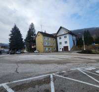 Stavebný pozemok 1001 m2 - Budovy pri ceste na pozemkoch pre bývanie v Majdane, Horné Orešany, obklopené stromami.