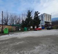 Stavebný pozemok 1001 m2 - Parkovisko na ulici Majdan v Horných Orešanoch, obklopené stromami a obytnými budovami.