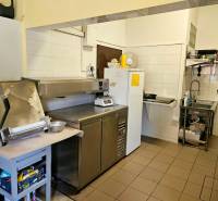 Predaj/odstúpenie zabehnutej gastro prevádzky s kuchyňou, Bratislava 2 - Kuchynské vybavenie v gastro priestore s nerezovými spotrebičmi a bielymi stenami.