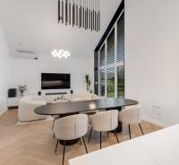 THE HOME ︱ PREDAJ - designový 5-izbový rodinný dom v Chorvátskom Grob - Obývačka v rodinnom dome s veľkým stolom, kreslami a televízorom na stene.