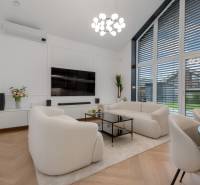 THE HOME ︱ PREDAJ - designový 5-izbový rodinný dom v Chorvátskom Grob - Obývačka v rodinnom dome s bielym nábytkom, veľkými oknami a televízorom na stene.
