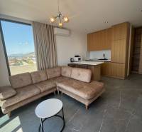 Ksamil – luxusné zariadené apartmány v Maledivách Európy - Obývacia izba rekreačného apartmánu s rohovou sedačkou, výhľadom a kuchynským kútom.