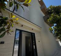 Ksamil – luxusné zariadené apartmány v Maledivách Európy - Fasáda rekreačného apartmánu v Ksamil, obklopená zeleňou a jasnou oblohou.