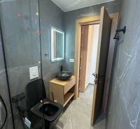 Ksamil – luxusné zariadené apartmány v Maledivách Európy - Kúpeľňa v rekreačnom apartmáne s čiernym sanitárnym zariadením a dreveným nábytkom.