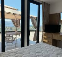 Ksamil – luxusné zariadené apartmány v Maledivách Európy - Interiér Rekreačného apartmánu s posteľou, skriňou a terasou s výhľadom na more.