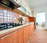 - EXKLUZÍVNE - PREDAJ - 3,5 IZBOVÝ BYT - LEVICE - Kuchyňa v 4-izbovom byte s plynovým sporákom a hnedými keramickými obkladačkami.