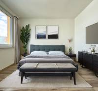 - EXKLUZÍVNE - PREDAJ - 3,5 IZBOVÝ BYT - LEVICE - Svetlá spálňa v 3-izbovom byte s veľkou posteľou, rastlinami a minimalistickým nábytkom.