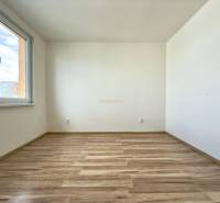 - EXKLUZÍVNE - PREDAJ - 3,5 IZBOVÝ BYT - LEVICE - Prázdna svetlá miestnosť s drevenou podlahou v 4-izbovom byte.