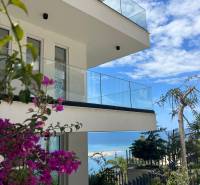  Albánsko, Sarandë – luxusné novostavby apartmánov v prvom rade - Rekreačný apartmán v Sarandë s výhľadom na more a kvetinovou dekoráciou.