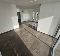  Albánsko, Sarandë – luxusné novostavby apartmánov v prvom rade - Interiér rekreačného apartmánu s veľkými oknami a lesklou dlažbou.