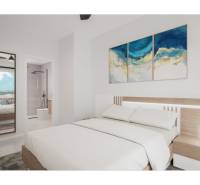 LOS ALCÁZARES -rekreačné apartmány s turistickou licenciou na prenájom - Svetlá spálňa s veľkou posteľou, obrazmi na stene a priľahlou kúpeľňou.