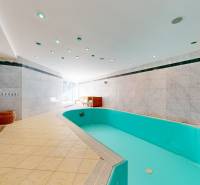 6-izbový rodinný dom s wellness a bazénom Záhorská Bystrica - Vila s vnútorným bazénom, obklopená svetlými dlaždicami a moderným osvetlením.