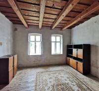 PREDAJ-vidiecky dom s veľkým pozemkom pod lesom, Nitr.Sučany, okr.PD - Izba v rodinnom dome s dreveným stropom, okná, skrinky, koberec na podlahe.