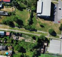SLOVREAL predaj pozemku Žiar nad Hronom - Letecký pohľad na pozemky pre bývanie v Žiari nad Hronom s cestou a parkovaním.
