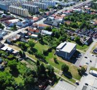 SLOVREAL predaj pozemku Žiar nad Hronom - Letecký pohľad na pozemky na bývanie v Žiari nad Hronom s budovami a zeleňou.