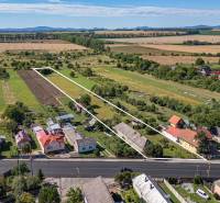 PREDAJ, Pozemok s rodinným domom Sečovce, okres Trebišov - Pozemky na bývanie v Sečovciach, zelené polia, niekoľko domov a veľká cesta vpredu.