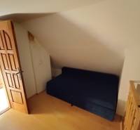 Na predaj chata pri jazere v Sklených Tepliciach - Izba s modrým gaučom, drevenými dverami na ulici Sklené Teplice a Chata.