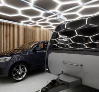 Exkluzívne garáže v projekte PARK3BA, Triblavina, Bratislava - Auto a karavan vo vnútri obchodných priestorov s osvetlením a drevenými stenami.