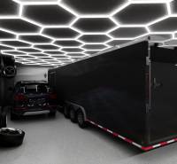 Exkluzívne garáže v projekte PARK3BA, Triblavina, Bratislava - Obchodné priestory s automobilom, prívesom, svetelným stropom a umeleckými plagátmi na stene.