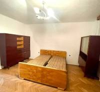 Vám ponúka Rodinný dom vo Veľkom Blahove - s ve - Spálňa v rodinnom dome so starším nábytkom a drevenou podlahou.