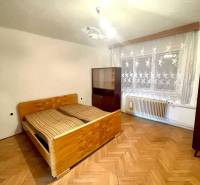 Vám ponúka Rodinný dom vo Veľkom Blahove - s ve - Interiér rodinného domu s drevenou podlahou, posteľou a záclonami na okne.