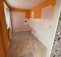 3 izbový byt na predaj,  80 m2, Zvolen - Podborová - Prázdna kuchyňa v 3-izbovom byte s oranžovo-ružovými stenami a vinylovou podlahou.