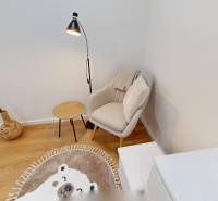 PRENÁJOM  Jednoizbový byt, Komenského, Senica - Kreslo s vankúšom, malý stolík, lampa a dekorácia v 1-izbovom byte.