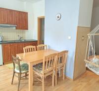 PREDAJ, Mezonetový apartmán v apartmánovom dome Horec, Donovaly - Kuchyňa so vstavanými skrinkami, jedálenským stolom a hojdacou stoličkou v 3-izbovom byte.