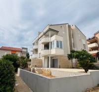 ☀NOVALJA (HR) - 3-izbový moderne zariadený apartmán, blízko pláže  - Bytový dom s balkónmi v Novalji, 3-izbové byty, obklopený zeleňou a kríkmi.