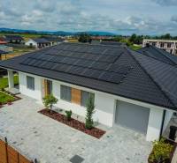 Predaj 4iz. novostavby RD s garážou na Modrovke 1km od diaľnice - Rodinný dom v Piešťanoch s fotovoltaickými panelmi na streche obklopuje zelená záhrada.