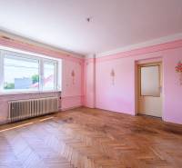 Rodinný dom s veľkým pozemkom na predaj – Vidiná, okres Lučenec - Ružové steny s kvetinovou výzdobou, drevená podlaha, veľké okno v rodinnom dome.