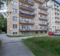 Priestranný 3 a pol izbový byt v Novom Smokovci - Bytový dom vo Vysokých Tatrách s balkónmi a parkoviskom pred budovou.