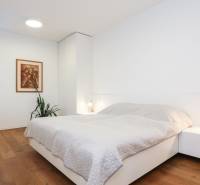 NADŠTANDARDNÝ 6i RD s bazénom, pozemok 1583 m2, BA V.-Rusovce - Spálňa v rodinnom dome s drevenou podlahou, obrazom a nočným stolíkom.