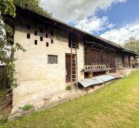 Exkluzívne na predaj drevenica s pozemkom 406 m2, Papradno - Pohľad na staršiu chatu v Papradne s drevenou konštrukciou a upraveným dvorom.