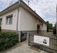 5 izbový rodinný dom Topoľčianky - Rodinný dom v Topoľčiankach s vchodom a bránou na kamenistej ceste.