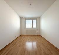 Priestranný 3-izbový byt s balkónom 68 m² Belinského - Prázdna svetlá miestnosť s laminátovou podlahou v 3-izbovom byte.