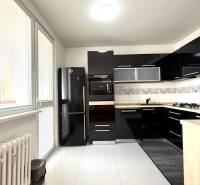 Priestranný 3-izbový byt s balkónom 68 m² Belinského - Kuchyňa v 3-izbovom byte s čiernou linkou, sporákom a bielou dlažbou.