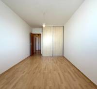 Priestranný 3-izbový byt s balkónom 68 m² Belinského - Izba s drevenou podlahou a veľkou vstavanou skriňou v 3-izbovom byte.