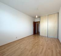 Priestranný 3-izbový byt s balkónom 68 m² Belinského - Prázdna izba s drevenou podlahou a vstavanou skriňou v 3-izbovom byte.