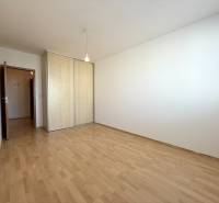 Priestranný 3-izbový byt s balkónom 68 m² Belinského - Priestranná izba s drevenou podlahou a vstavanou skriňou v 3-izbovom byte.