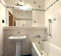 Priestranný 3-izbový byt s balkónom 68 m² Belinského - Kúpeľňa v 3-izbovom byte s bielymi obkladačkami, vaňou a umývadlom.