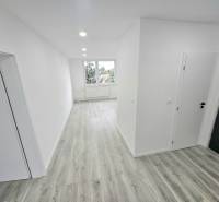 3 izbový byt Bánovce nad Bebravou / CENTRUM- STRED / 56 m2 / NOVÁ REKO - Chodba v 3-izbovom byte s drevenou podlahou a bielymi stenami.
