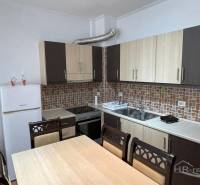 Sarandë - novozariadený apartmán v tesnej blízkosti mora - Kuchyňa v Rekreačnom apartmáne s jedálenským stolom a bielymi spotrebičmi.
