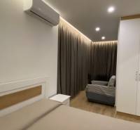Sarandë - novozariadený apartmán s výhľadom na more - Interiér Rekreačného apartmánu s posteľou, pohovkou, závesmi a klimatizáciou.